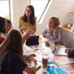 Female Manager Leads Meeting Around Table In Design Office